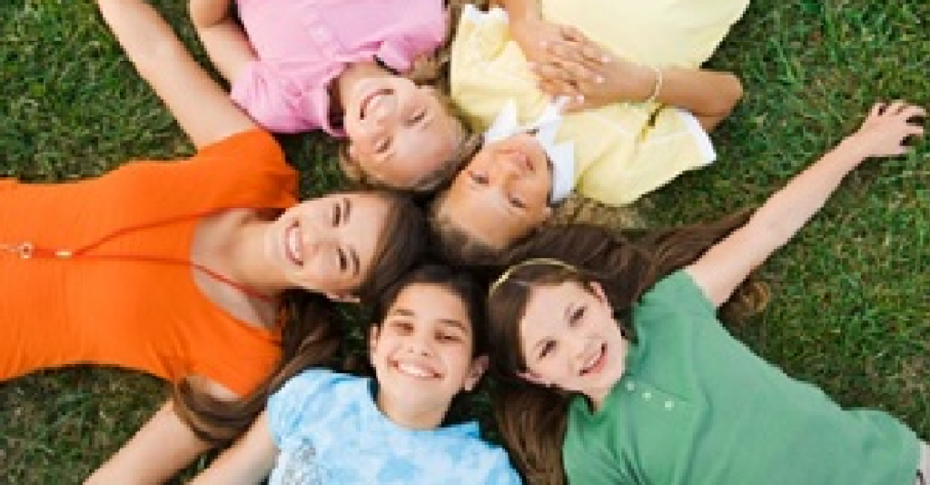 Picture of children laying in a circle in the grass