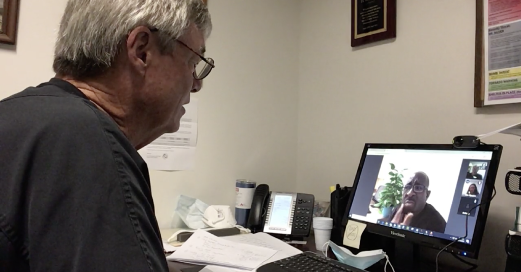 Picture of Dr. Rob Doherty talking to a patient via a computer webcam